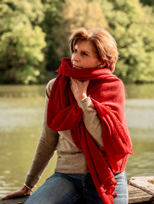 femme portant une écharpe rouge le long d'une rivière