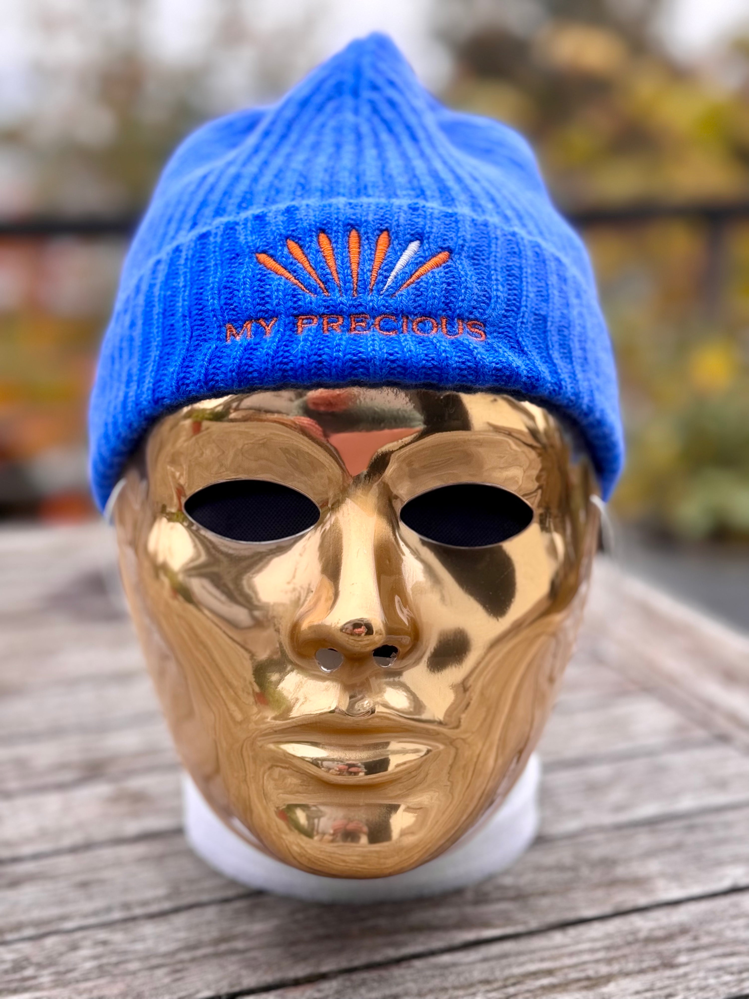 mannequin avec masque doré portant un bonnet bleu