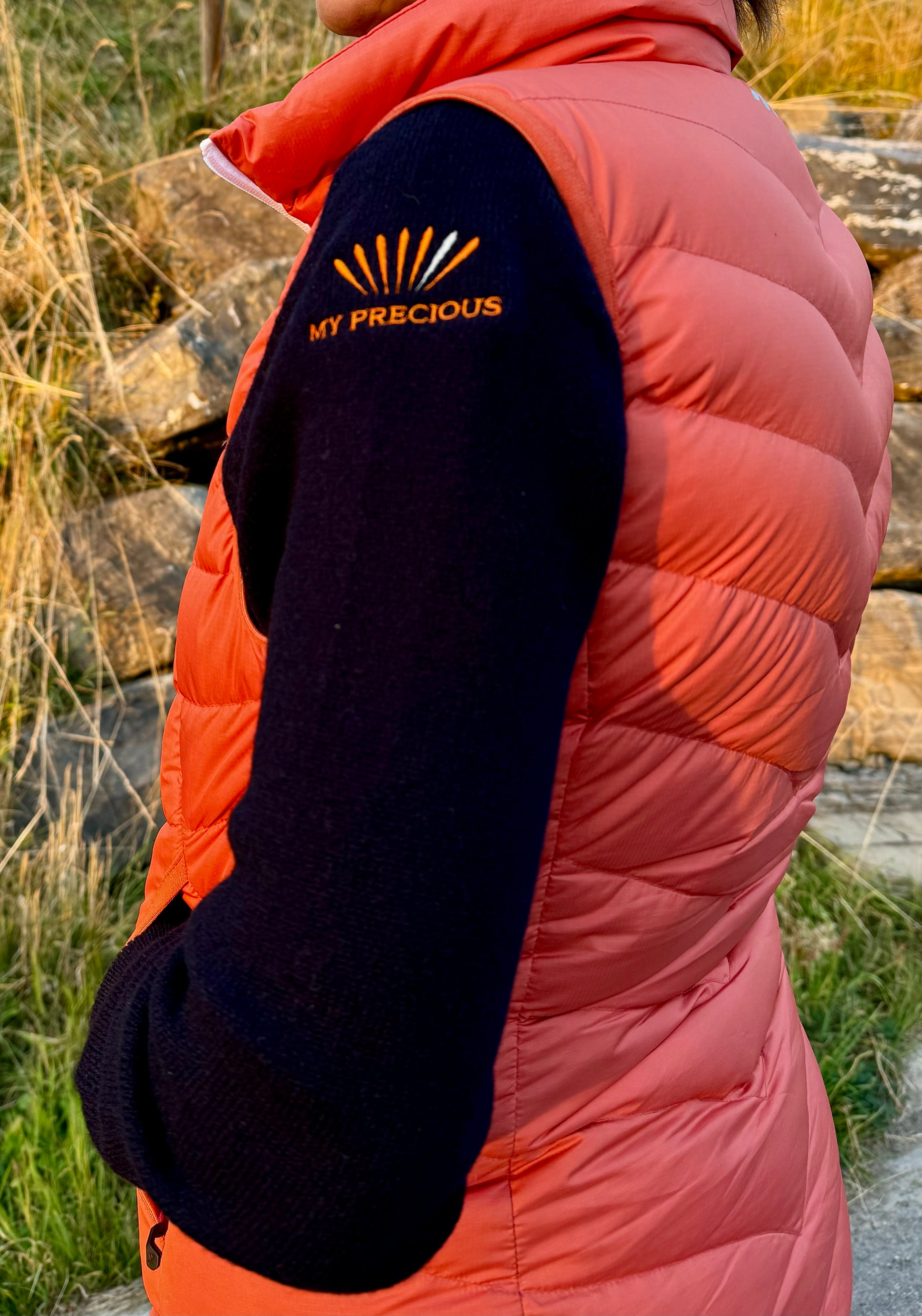 personne portant un pull noir avec une doudoune orange sans manche