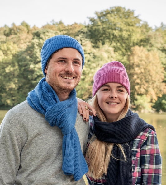homme et femme portant une écharpe et bonnet bleu et rose le long d'une rivière