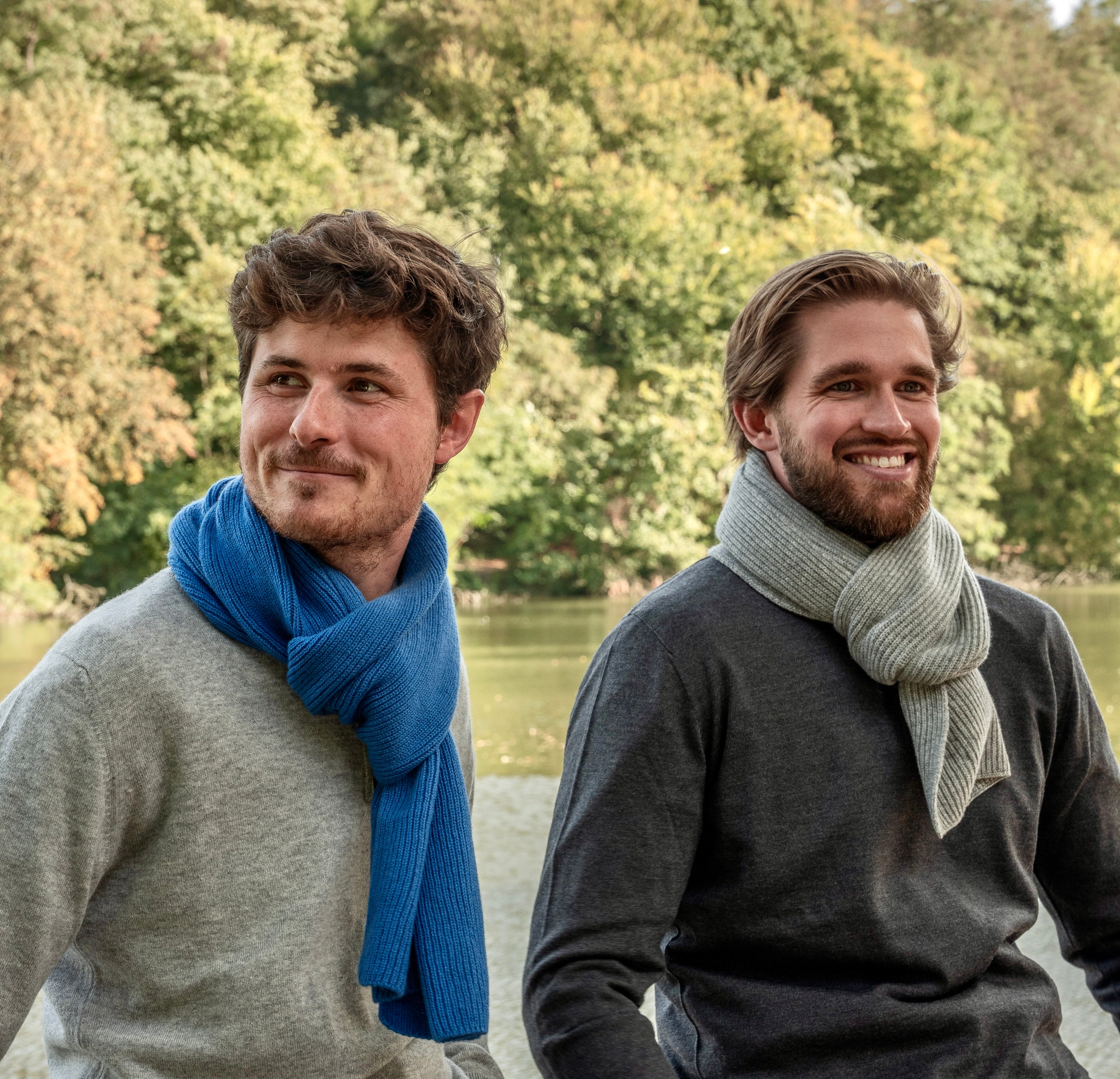 deux hommes aux cheveux bruns et barbus portant pull gris et écharpes bleues et grises