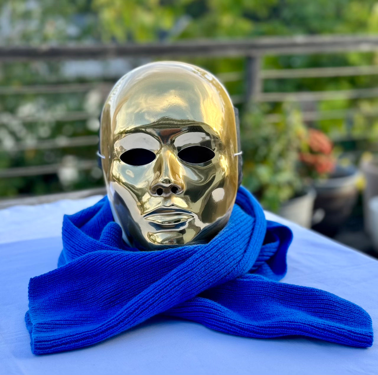 mannequin avec masque doré et une écharpe bleue